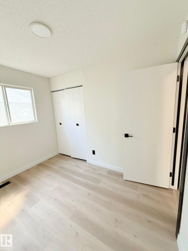 Room featuring light wood-finish flooring, white walls, and a flat panel ceiling light - 11628 151 Avenue Nw, Edmonton, AB 