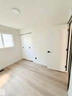 Room featuring light wood-finish flooring, white walls, and a flat panel ceiling light - 