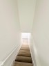 Staircase with wood-finish treads, white painted risers, and a white handrail - 11628 151 Avenue Nw, Edmonton, AB 