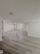 Spacious interior with light wood-finish flooring, white walls, and recessed lighting - 