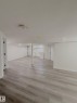 Spacious interior with light wood-finish flooring, white walls, and recessed lighting - 11628 151 Avenue Nw, Edmonton, AB 