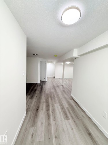 Expansive interior space featuring wood-finish flooring, white walls, and recessed lighting - 11628 151 Avenue Nw, Edmonton, AB 