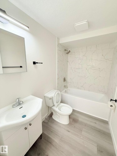 Bathroom featuring a white vanity with integrated sink, chrome faucet, and matte black hardware - 11628 151 Avenue Nw, Edmonton, AB 