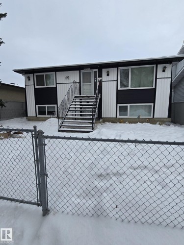 Split-level exterior featuring a black and white facade with vertical siding accents - 11927 85 Street Nw, Edmonton, AB - Outdoor