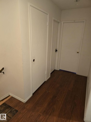 Hallway featuring wood-finish flooring, white walls, and white doors - 11927 85 Street Nw, Edmonton, AB - Indoor Photo Showing Other Room