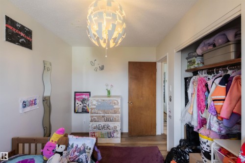 Interior room featuring a contemporary ceiling fixture, light-toned walls, and wood-finish flooring - 5931 138 Avenue, Edmonton, AB - Indoor