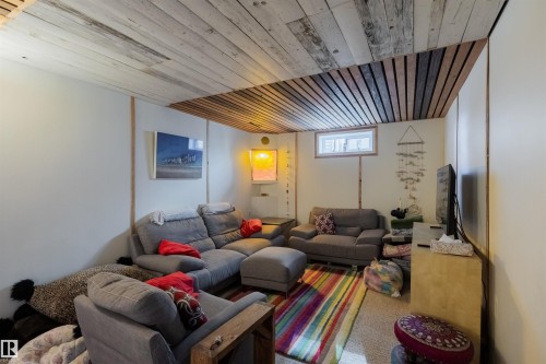 Recessed living area featuring a plank wood ceiling, light-toned wall panels, and a prominent window - 5931 138 Avenue, Edmonton, AB - Indoor