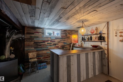 Custom-built bar featuring a wood-finish countertop and paneled base - 5931 138 Avenue, Edmonton, AB - Indoor