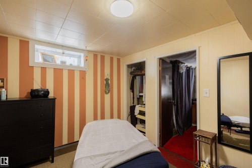 Room featuring striped accent wall, drop ceiling, and a high horizontal window - 5931 138 Avenue, Edmonton, AB - Indoor