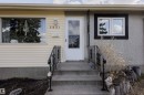 Exterior featuring a concrete porch with wrought iron railings, a white storm door, and contrasting siding and stucco finishes - 5931 138 Avenue, Edmonton, AB  - Outdoor 