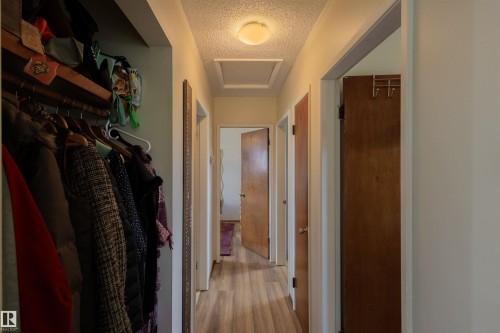 Hallway featuring wood-finish flooring, solid core doors, a flush-mount ceiling light, and access panel - 5931 138 Avenue, Edmonton, AB - Indoor Photo Showing Other Room