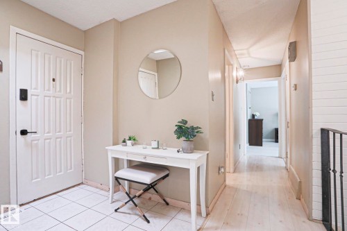 Entryway featuring white panel door with black hardware, white square tile flooring, and light neutral wall paint - 1214 85 Street Nw, Edmonton, AB - Indoor