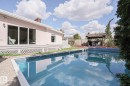 Backyard featuring an in-ground swimming pool with steps, surrounding pea gravel, and a detached wooden gazebo - 1214 85 Street Nw, Edmonton, AB  - Outdoor With In Ground Pool With Deck Patio Veranda 