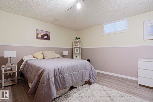 Room featuring two-tone wall paint, wood-finish flooring, and white baseboards - 1214 85 Street Nw, Edmonton, AB - Indoor Photo Showing Bedroom