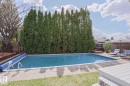 Rectangular swimming pool with a patterned tile border and metal ladder - 1214 85 Street Nw, Edmonton, AB  - Outdoor With In Ground Pool 