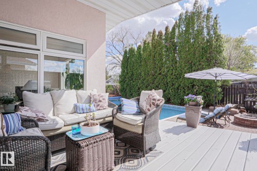 Expansive outdoor deck area featuring a built-in swimming pool and a brick fire pit - 1214 85 Street Nw, Edmonton, AB - Outdoor With Deck Patio Veranda With Exterior