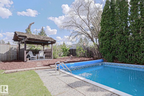 Outdoor swimming pool with integrated steps, surrounded by a textured concrete deck - 1214 85 Street Nw, Edmonton, AB - Outdoor With In Ground Pool With Backyard