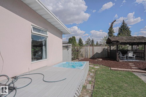 Rear deck with integrated hot tub, complemented by a covered gazebo structure and a partially fenced yard - 1214 85 Street Nw, Edmonton, AB - Outdoor