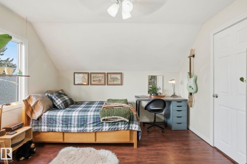 Attic room featuring sloped ceilings, a window with exterior views, and wood-finish flooring - 4 Langley Dr, Fort Saskatchewan, AB - Indoor Photo Showing Bedroom