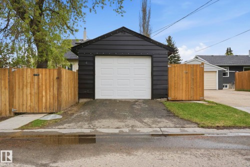 Detached garage featuring black siding and a white panel garage door - 4 Langley Dr, Fort Saskatchewan, AB - Outdoor