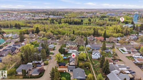 Aerial view of a residential area featuring suburban homes with varied rooflines and mature trees - 4 Langley Dr, Fort Saskatchewan, AB - Outdoor With View