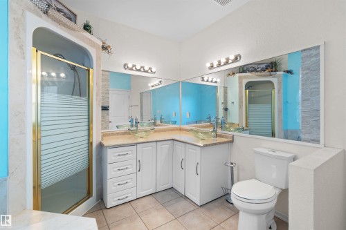Bathroom featuring a corner vanity with dual vessel sinks, white cabinetry, and a light-toned countertop - 205 10939 82 Avenue, Edmonton, AB - Indoor Photo Showing Bathroom