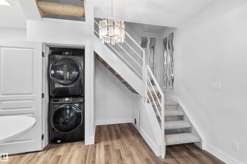 Contemporary staircase with white railings and light-toned carpeted treads - 205 10939 82 Avenue, Edmonton, AB - Indoor Photo Showing Laundry Room