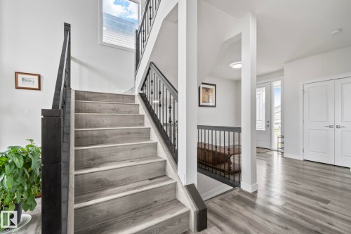 Staircase featuring wood-finish treads and risers with black wrought iron spindles - 334 Aston Close, Leduc, AB - Indoor Photo Showing Other Room