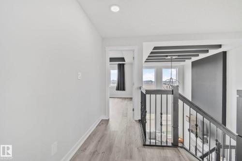 Upper-level hallway featuring wood-finish flooring, recessed lighting, and a doorway leading to an additional space - 334 Aston Close, Leduc, AB - Indoor Photo Showing Other Room