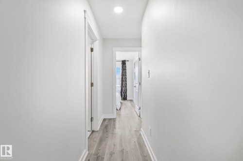 Hallway featuring wood-finish flooring, white painted walls, recessed lighting, and white baseboards - 334 Aston Close, Leduc, AB - Indoor Photo Showing Other Room
