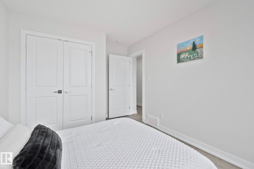 Bedroom featuring light gray walls, white trim, and wood-finish flooring - 334 Aston Close, Leduc, AB - Indoor Photo Showing Bedroom