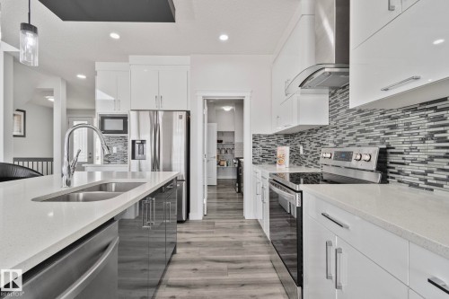 Contemporary kitchen featuring light quartz countertops and wood-finish flooring - 334 Aston Close, Leduc, AB - Indoor Photo Showing Kitchen With Double Sink With Upgraded Kitchen