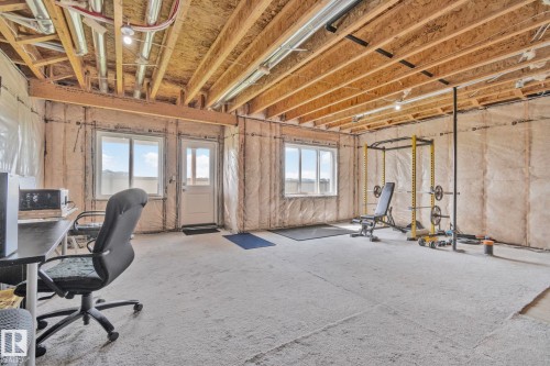 Unfinished basement with exposed ceiling joists and insulation-lined walls - 334 Aston Close, Leduc, AB - Indoor