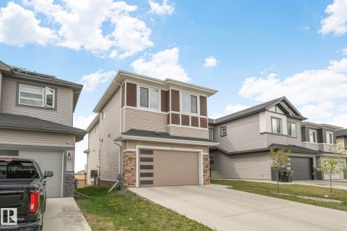 Contemporary two-story residence featuring light-colored siding, a brown trim accent, and a single-car garage - 334 Aston Close, Leduc, AB - Outdoor With Facade