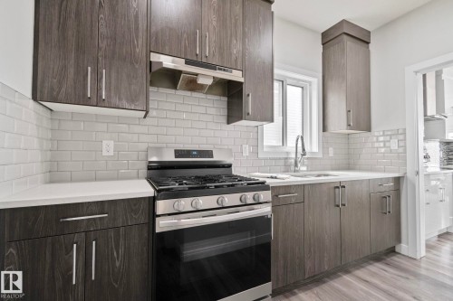 Modern kitchen featuring wood-finish cabinetry, white subway tile backsplash, and light countertops - 334 Aston Close, Leduc, AB - Indoor Photo Showing Kitchen With Upgraded Kitchen
