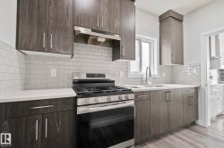 Modern kitchen featuring wood-finish cabinetry, white subway tile backsplash, and light countertops - 