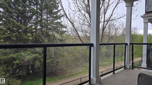 Private balcony featuring concrete flooring, white architectural columns, and clear glass panel railings with black metal frames - 90 3010 33 Avenue, Edmonton, AB - Outdoor