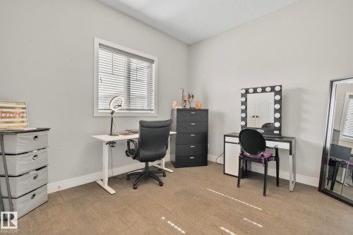 Spacious room featuring neutral grey walls, light-toned carpeting, and a white framed window with horizontal blinds - 67 Enchanted Way N, St. Albert, AB - Indoor Photo Showing Office
