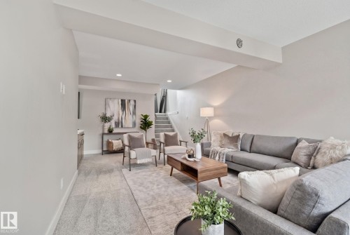 Spacious open-concept living area featuring light gray carpeting and recessed lighting - 67 Enchanted Way N, St. Albert, AB - Indoor Photo Showing Living Room
