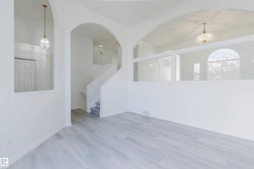 Light-toned wood-finish flooring complements the white walls and trim - 13755 131B Avenue, Edmonton, AB - Indoor Photo Showing Other Room