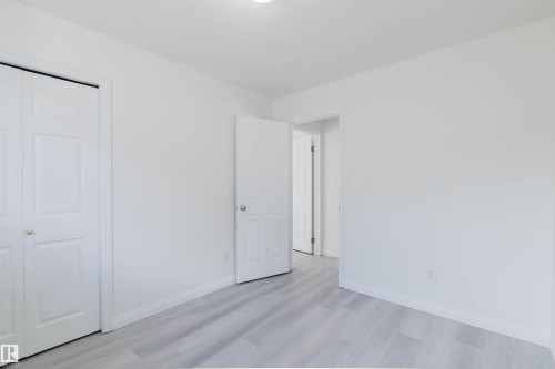 White walls complementing gray wood-finish flooring - 13755 131B Avenue, Edmonton, AB - Indoor Photo Showing Other Room