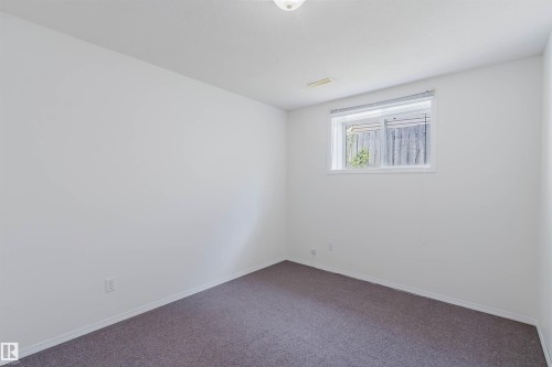 Room featuring neutral-toned walls, recessed window with blinds, and dark grey carpeting - 13755 131B Avenue, Edmonton, AB - Indoor Photo Showing Other Room