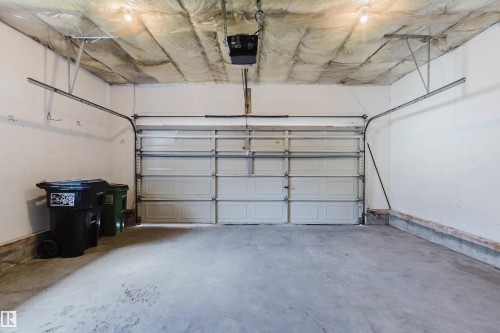 Spacious garage featuring a concrete floor, white painted walls, and an automatic overhead door opener - 13755 131B Avenue, Edmonton, AB - Indoor Photo Showing Garage