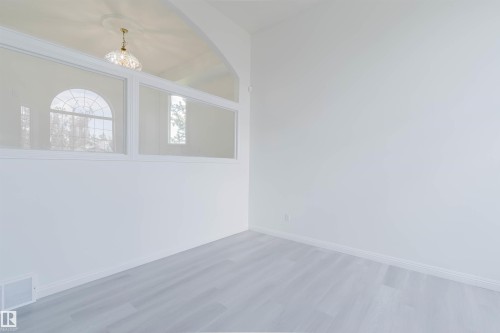 Light gray wood-finish flooring complements white walls - 13755 131B Avenue, Edmonton, AB - Indoor Photo Showing Other Room
