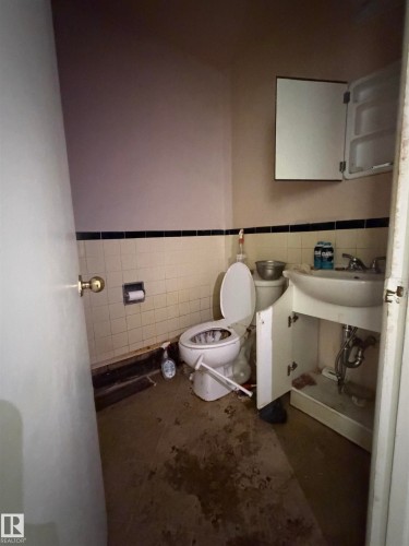 Bathroom with a wall-mounted sink, a matching wall cabinet, and a tiled wall - 17 6215 98 Avenue, Edmonton, AB - Indoor