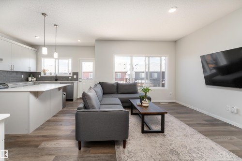 Contemporary open-concept living space featuring wood-finish flooring, recessed lighting, and large windows - 5323 Lark Landing Landing, Edmonton, AB - Indoor Photo Showing Living Room
