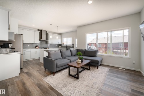 Open-concept living space featuring wood-finish flooring, recessed lighting, and large windows - 5323 Lark Landing Landing, Edmonton, AB - Indoor
