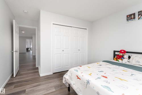 Bedroom featuring wood-finish flooring, a bi-fold closet with panel doors, and a neutral wall color - 5323 Lark Landing Landing, Edmonton, AB - Indoor Photo Showing Bedroom