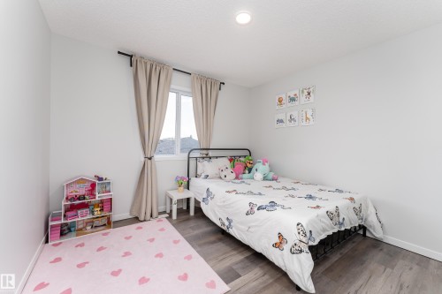 Bedroom featuring wood-finish flooring, a window with curtain rods, and recessed ceiling lighting - 5323 Lark Landing Landing, Edmonton, AB - Indoor Photo Showing Bedroom