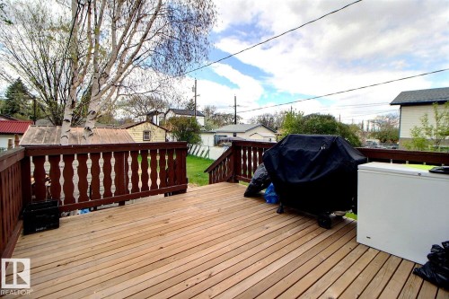 Outdoor wood deck with dark stained balusters and a light wood surface - 11626 87 Street, Edmonton, AB - Outdoor With Deck Patio Veranda With Exterior